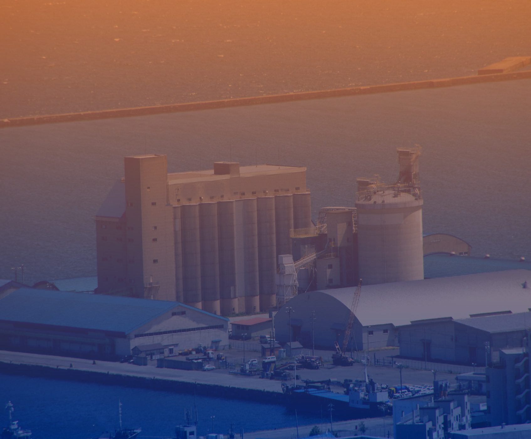 Industrial harbor with silos at sunset